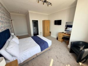 a bedroom with a bed and a desk and a chair at Imperial Lodge in Great Yarmouth +75 photos