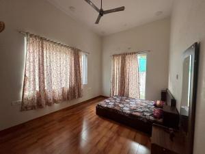 a living room with a bed and two windows at shreeraj farms in Kolshet