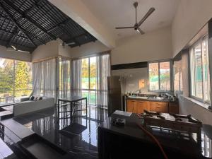 a living room with a ceiling fan and a kitchen at shreeraj farms in Kolshet