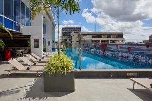 a large swimming pool with lounge chairs on a building at Radisson RED Cebu Mandaue in Cebu City