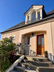 a house with stairs leading up to a door at La Pause Normande - Bed & Breakfast in Bayeux
