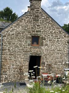 a stone building with a window and some chairs at TyAngeLLouis in Brandivy