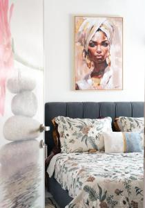 a bedroom with a bed with a painting on the wall at 7th sky Aristotelous in Thessaloniki