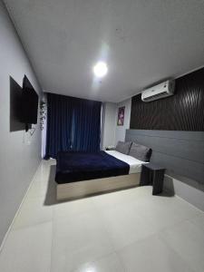 a bedroom with a bed with a blue blanket at Kay hotel in Angeles