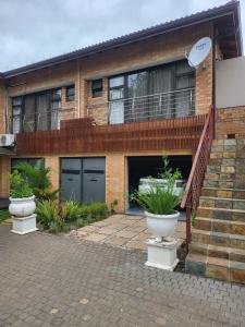 a brick house with two garage doors and some plants at Zungu b&b in KwaDukuza