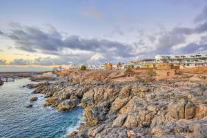a group of buildings on top of a rocky coastline at Apartamento Luminoso Lagos Cotillo in El Cotillo