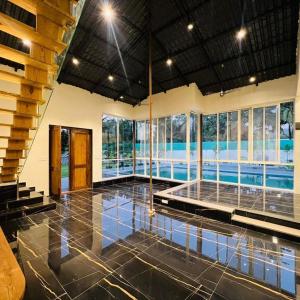 a large room with a swimming pool in a house at shreeraj farms in Kolshet