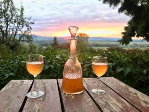 two glasses of beer on a wooden table with the sunset at Kofal Pince 1 in Raposka