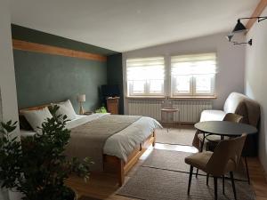 a bedroom with a bed and a table and a couch at Zielony Pokój in Ojców