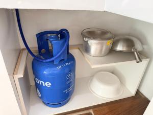 a blue jug sitting on a shelf in a cabinet at Manatad Transient Family 3 in Surigao