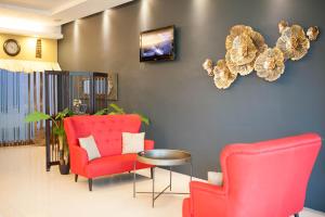 a living room with two red chairs and a table at Inn86 in Bintulu