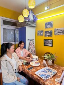 two women sitting at a table in a restaurant at Beverly Hills Home stay in Darjeeling