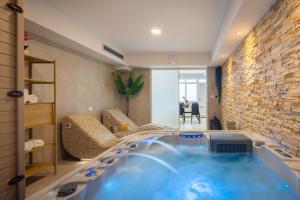 a large blue tub in a room with a stone wall at Villa Ante - Private Pool, Wellness & Gym in Šestanovac