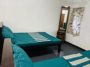 a bedroom with a green bed and a mirror at NR New Guest in Nilaveli
