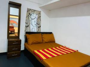 a bedroom with a bed with a dresser and a mirror at NR New Guest in Nilaveli