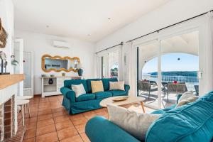 a living room with a blue couch and a table at Villa Casa de Olives by Escape Home in Cala Galdana