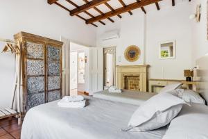 two beds in a white bedroom with a fireplace at Villa Casa de Olives by Escape Home in Cala Galdana +54 photos