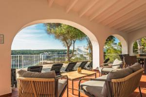 a patio with chairs and tables on a balcony at Villa Casa de Olives by Escape Home in Cala Galdana