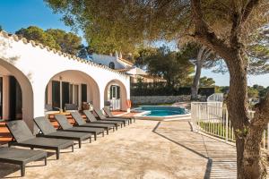 a patio with lounge chairs next to a swimming pool at Villa Casa de Olives by Escape Home in Cala Galdana