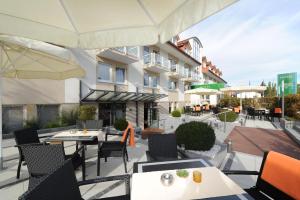 an outdoor patio with tables and chairs and a building at Hotel Markkleeberger Hof in Markkleeberg