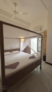 a large bed in a room with a large window at Yellow bay inn in Arugam Bay +40 photos