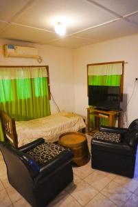 a living room with two chairs and a television at La Casa de Doña Adela in Eugenio Bustos