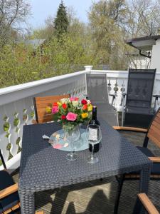 a table with a vase of flowers on a balcony at Strandvilla Rheingold in Göhren