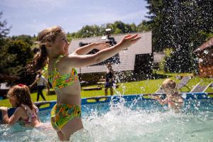 a young girl playing in the water at a fountain at Chata 70 Dřevěnka Prkenný Důl, Žacléř, Krkonoše in Žacléř