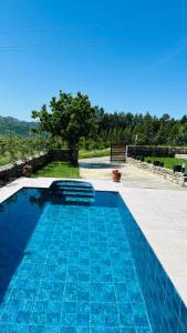 a blue swimming pool with a view of a field at Nora's Chalet in Fshati i Ri