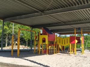 a playground with colorful equipment in a park at Vakantiepark 't Strandheem in Opende +24 photos