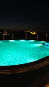 a large swimming pool at night with blue lights at Velora The Luxury Resort in Māndu
