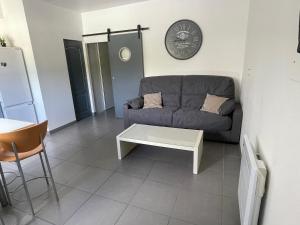 a living room with a couch and a table at Villa kaja in Saint-Porchaire