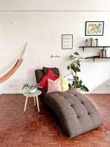 a living room with a couch with pillows and a table at Di Vine in Maputo