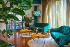 a living room with green furniture and a tv at Hotel Greenside Texel in De Koog