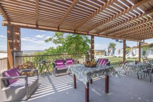 a patio with purple chairs and a table on a deck at El Encanto in Villarrasa