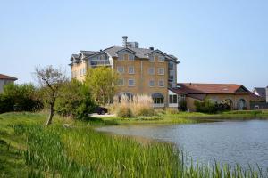 a large building next to a body of water at Hotel Greenside Texel in De Koog