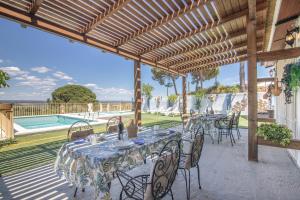 a patio with a table and chairs and a pool at El Encanto in Villarrasa