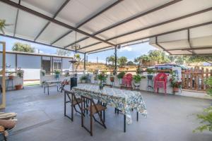 a covered patio with tables and chairs and a table and chairsktop at El Encanto in Villarrasa