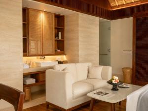 a living room with a couch and a table at REVĪVŌ Wellness Resort Nusa Dua Bali in Nusa Dua