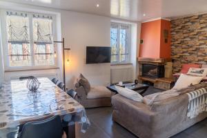 a living room with a table and a fireplace at Gîte de marthe in Sainte-Colombe-de-Peyre