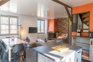 a kitchen and living room with a table and a couch at Gîte de marthe in Sainte-Colombe-de-Peyre
