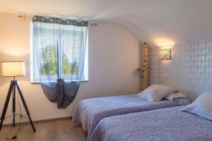a bedroom with two beds and a window at Gîte de marthe in Sainte-Colombe-de-Peyre