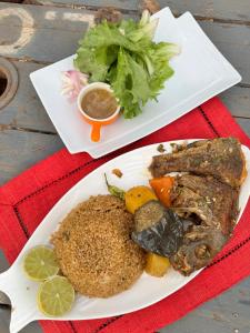 a plate of food with meat and vegetables on a table at Nougouranch in Rufisque