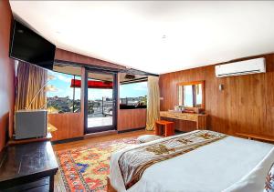 a bedroom with a large bed and a large window at Sky Suites in Seminyak