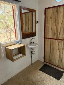 a bathroom with a sink and a wooden door at Nougouranch in Rufisque +21 photos