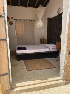 a small bedroom with a bed in a room at Nougouranch in Rufisque