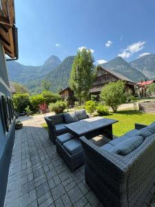 a patio with couches and a table on a patio at Chalet am Sonnenhang in Obertraun