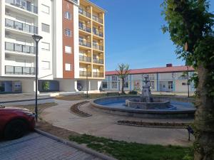 a fountain in a courtyard in front of a building at Top Spa apartman in Banja Koviljača