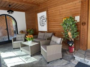 a patio with wicker chairs and tables and a door at Pension Wald in Faistenau