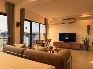 a living room with two couches and a flat screen tv at Mr Oh in Phuket Karon in Ka Rorn